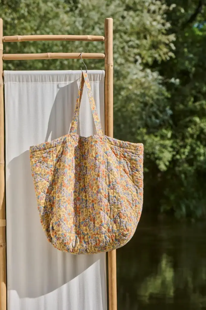 Bolsa acolchada amarilla con flores